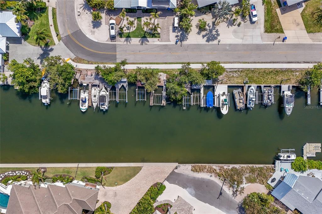 An aerial view shows a canal lined with private boat docks and residential properties — 221 85TH STREET, HOLMES BEACH, FL