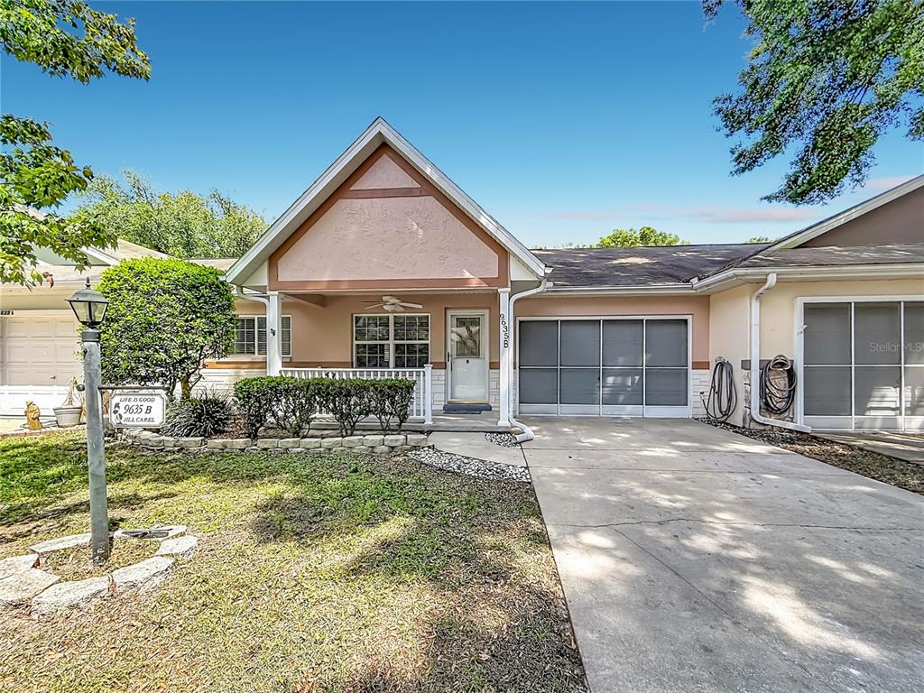 A single-story house features a front porch, a concrete driveway, and a garage with screens — 9635 SW 94TH TERRACE UNIT B, OCALA, FL