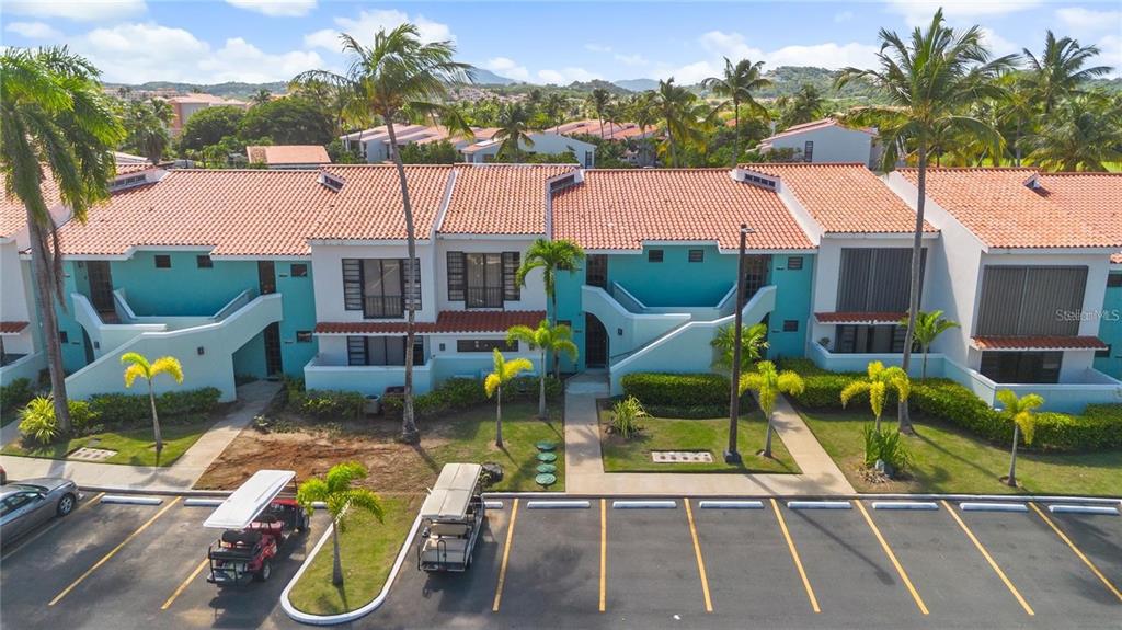 An aerial view shows a row of teal townhouses with terracotta roofs and palm trees — Palmas del Mar FAIRLAKES VILLAGE UNIT 655, HUMACAO, PR