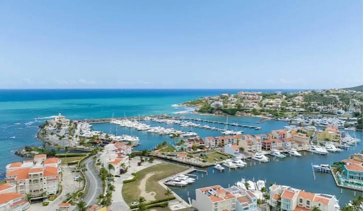 An aerial view shows a coastal marina with numerous boats docked near residential buildings — Palmas del Mar FAIRLAKES VILLAGE UNIT 655, HUMACAO, PR