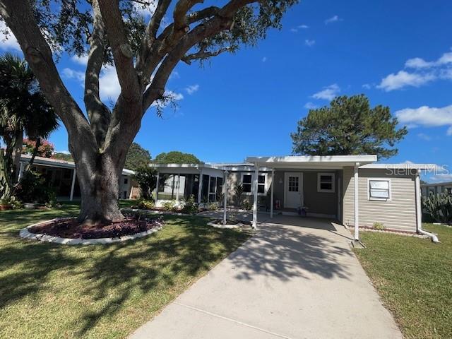 A single-story house with a large tree in the front yard and a concrete driveway — 909 ORCHID STREET, LADY LAKE, FL