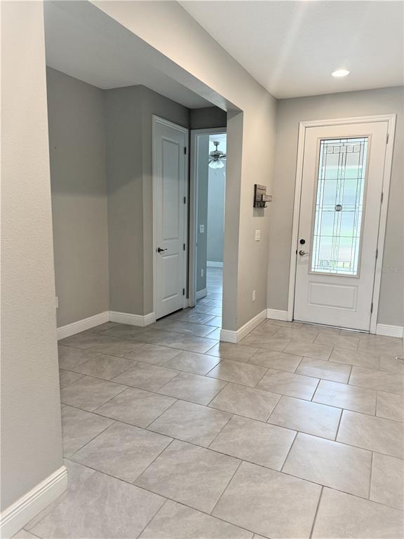 A tiled entryway features a white front door with glass panels and an interior hallway — 1315 YORKSHIRE COURT, DAVENPORT, FL