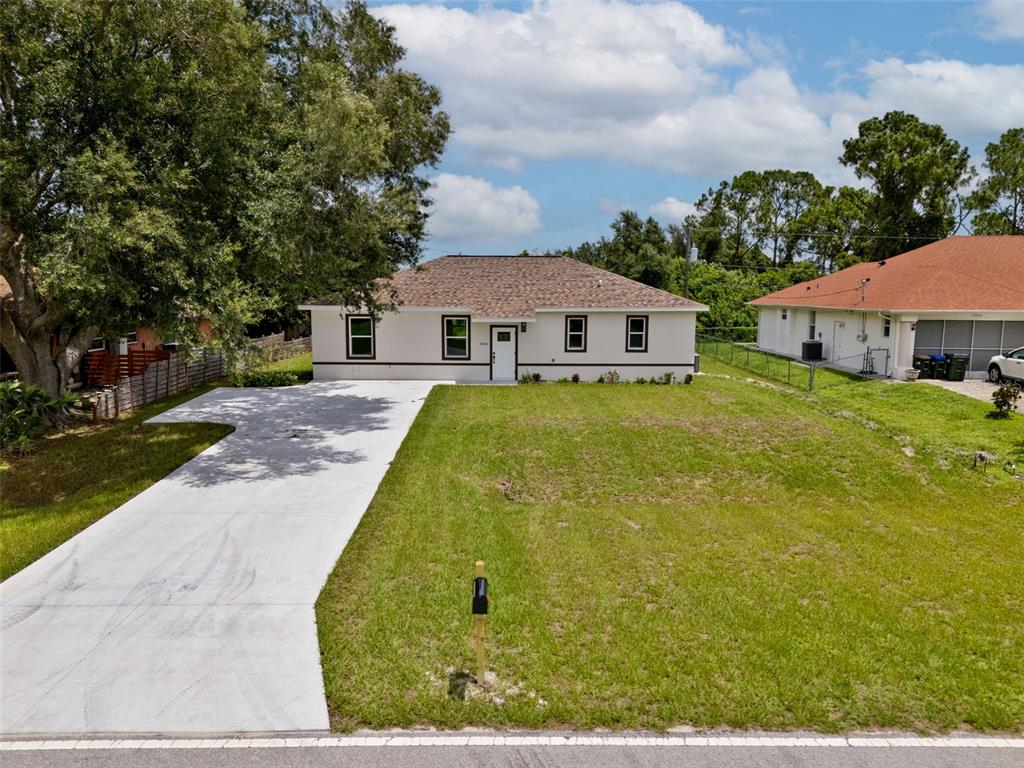 An aerial view of a single-story house with a white exterior, dark roof, and driveway — 8580 W PRICE BOULEVARD, NORTH PORT, FL