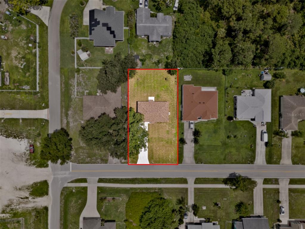 This aerial view shows a single-story house on a rectangular lot with a paved driveway — 8580 W PRICE BOULEVARD, NORTH PORT, FL