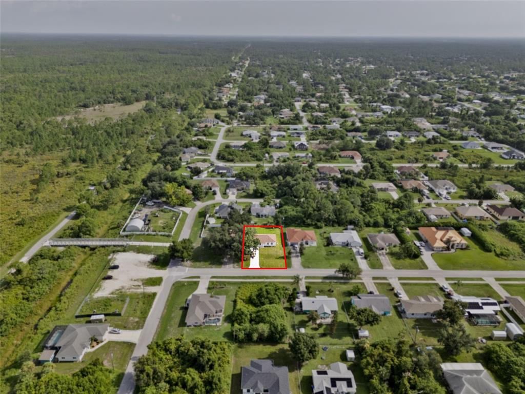 An aerial view shows a residential neighborhood with a red-outlined house in the foreground — 8580 W PRICE BOULEVARD, NORTH PORT, FL