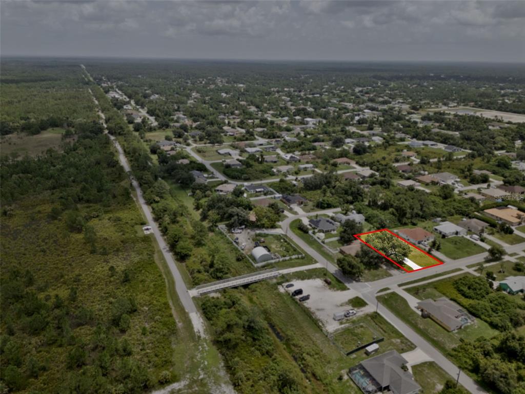 An aerial view shows a rectangular residential lot outlined in red within a suburban neighborhood — 8580 W PRICE BOULEVARD, NORTH PORT, FL