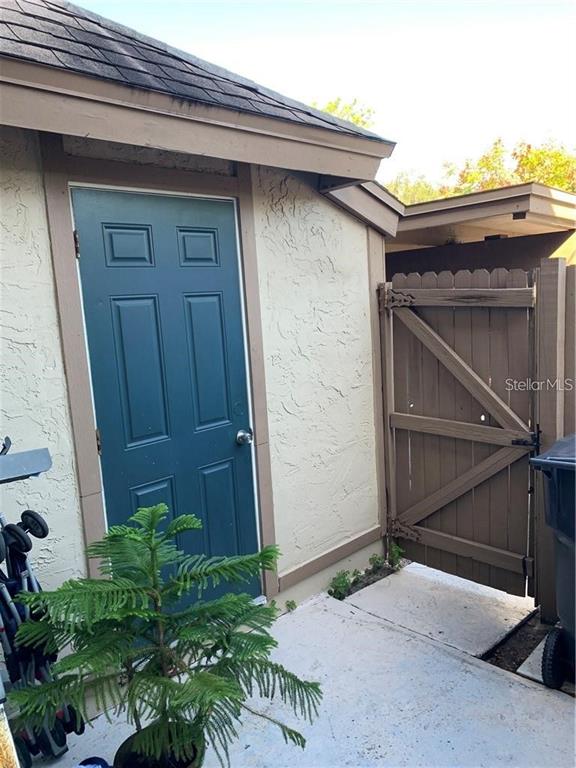 A teal door and a wooden gate are visible on the exterior of a building — 913 BUCK COURT, BRANDON, FL
