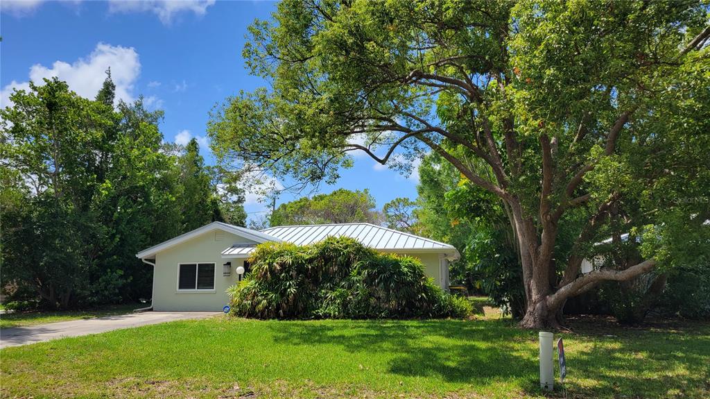 A living room with light-colored walls, speckled flooring, a ceiling fan, and a kitchen pass-through — 640 47TH STREET, SARASOTA, FL