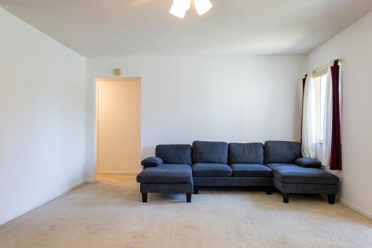 A living room features a large dark blue sectional sofa on beige carpet — 327 Pine Ridge Circle # 2, FL 33463, FL
