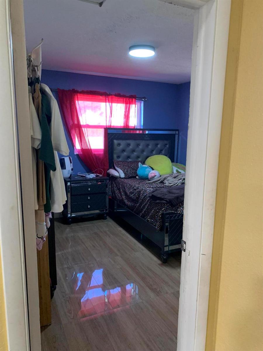A view through a doorway into a bedroom with blue walls and a dark bed — 1014 Old Boynton Road, Boynton Beach FL 33426, BOYNTON BEACH, FL