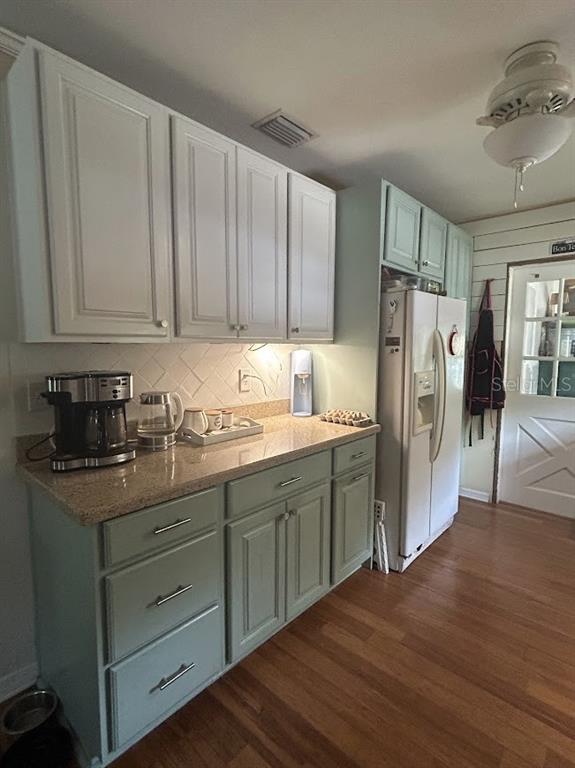 A kitchen features light green lower cabinets, white upper cabinets, granite countertops, and wood flooring — 14635 DUPREE ROAD, WIMAUMA, FL