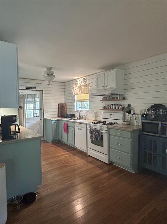A kitchen features light green cabinets, white shiplap walls, and wood flooring — 14635 DUPREE ROAD, WIMAUMA, FL
