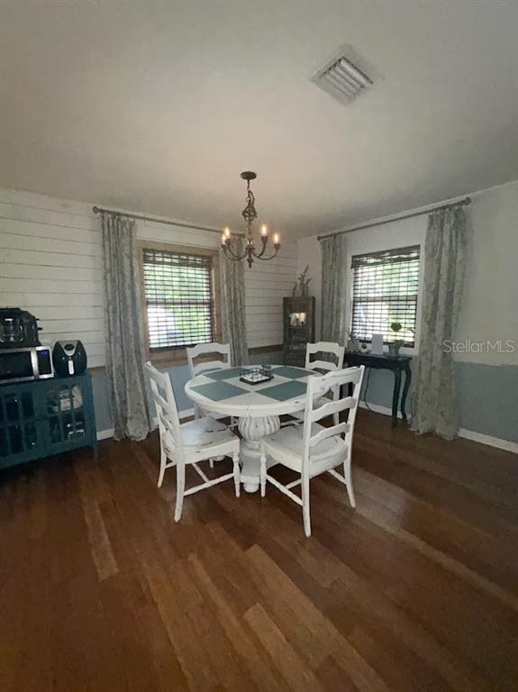 A dining room features a round white table, four chairs, shiplap walls, and hardwood floors — 14635 DUPREE ROAD, WIMAUMA, FL