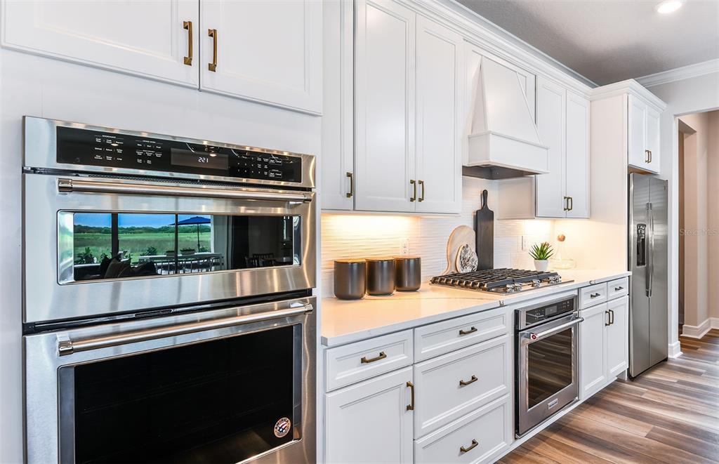 A modern kitchen features white cabinetry, stainless steel appliances, and a gas cooktop — 14421 DAYSTAR COURT, PARRISH, FL