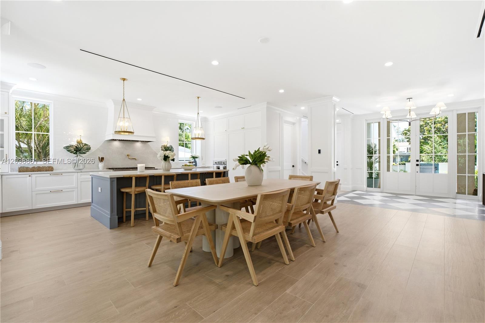 A bright, open-concept kitchen and dining area features light wood floors and white cabinetry — 6751 SW 76th Ter, South Miami FL 33143, SOUTH MIAMI, FL