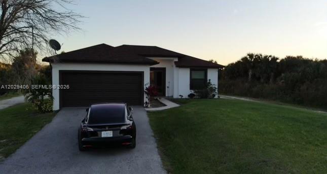 A single-story house with a dark roof, white exterior, and a black car in the driveway — 490 NW 37 AV., Naples FL 34120, NAPLES, FL