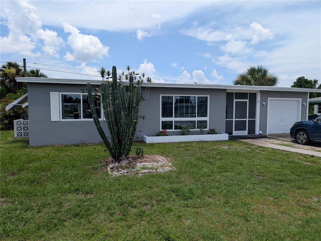 A single-story gray house with a large cactus in the front yard and a garage — 22311 MIDWAY BOULEVARD, PORT CHARLOTTE, FL