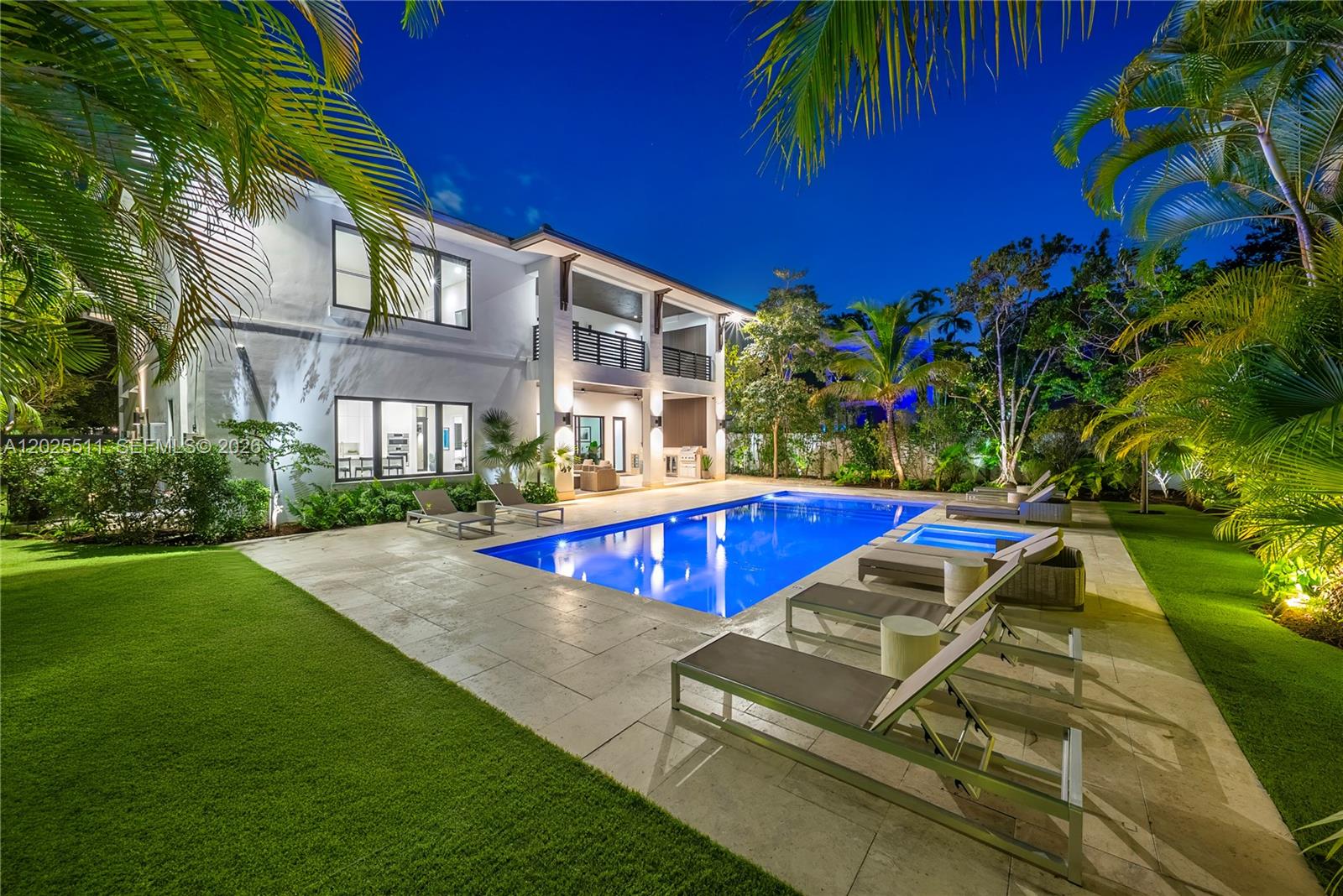 A two-story house exterior features a swimming pool, patio, and lounge chairs at night — 5753 SW 31st St, Miami FL 33155, MIAMI, FL