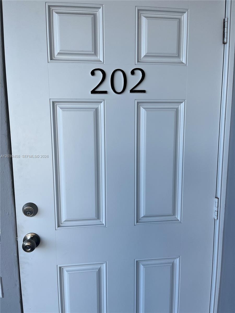 A white door with the number 202 and two black door handles — 350 75th St # 202, Miami Beach FL 33141, MIAMI BEACH, FL