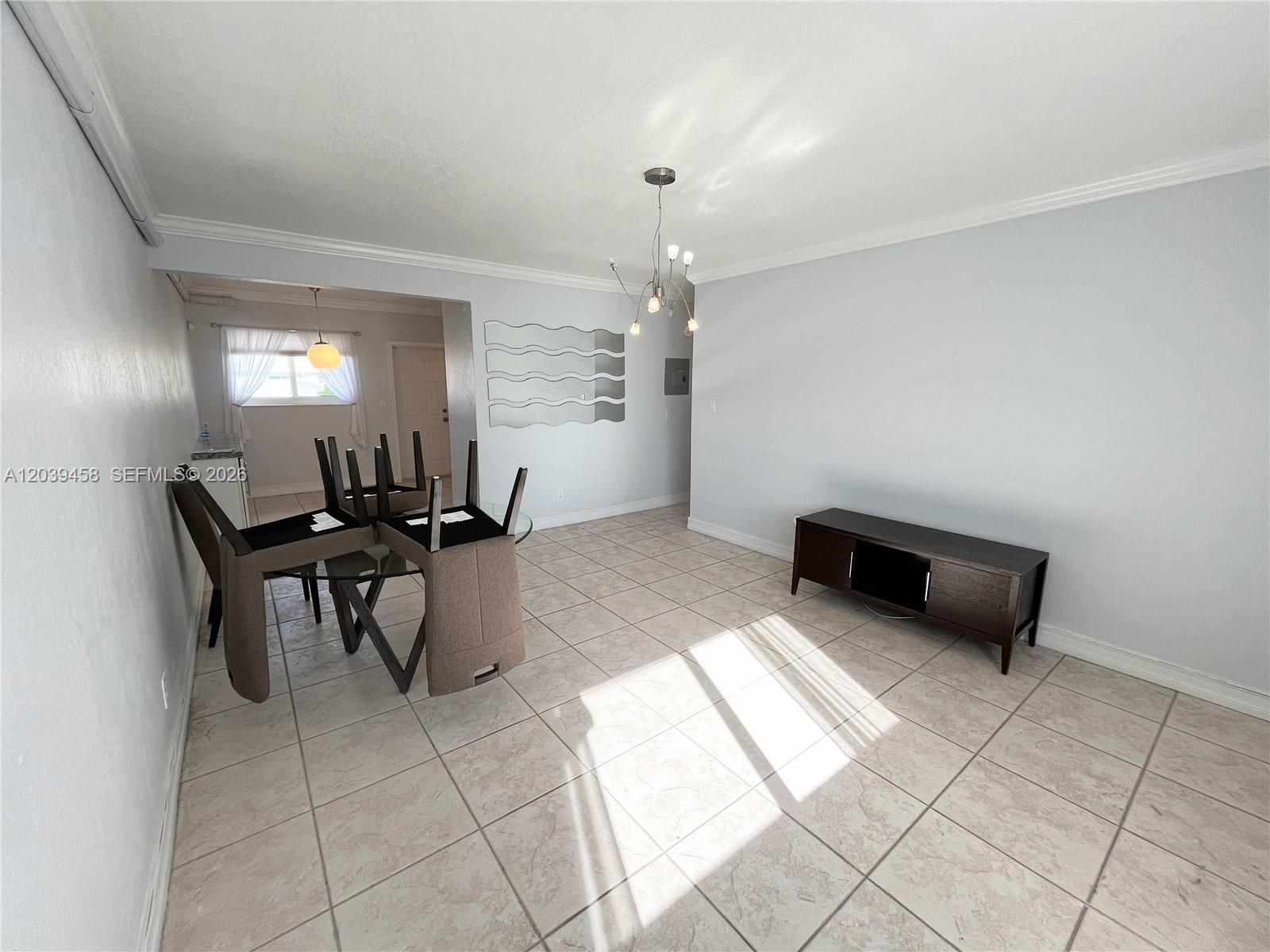 A dining area with tile flooring, a glass table with chairs, and a media console — 350 75th St # 202, Miami Beach FL 33141, MIAMI BEACH, FL