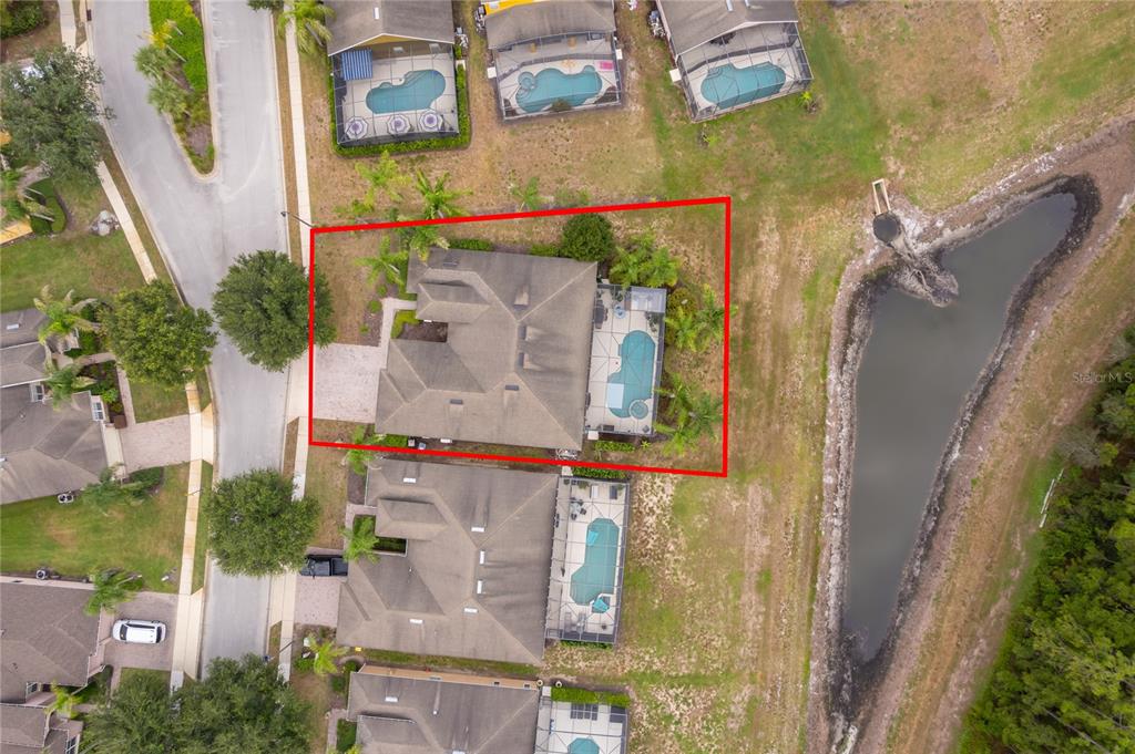 An aerial view shows a single-family home with a pool and screened lanai — 124 YELLOW SNAPDRAGON DRIVE, DAVENPORT, FL