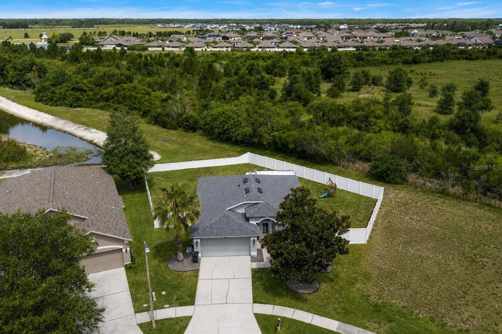 An aerial view shows a single-story house with a white fence and a large yard — 4529 MARCHMONT BOULEVARD, LAND O LAKES, FL