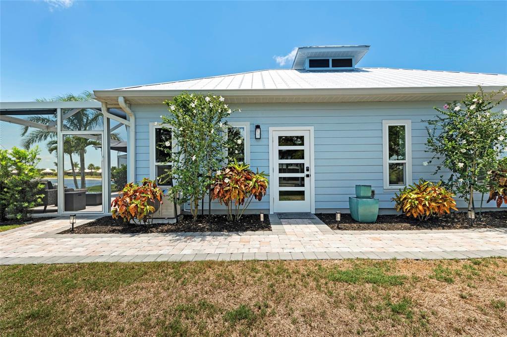 The exterior of a light blue house features a white door, windows, and landscaping — 8115 SW SAND CRANE CIRCLE LOT 2, ARCADIA, FL