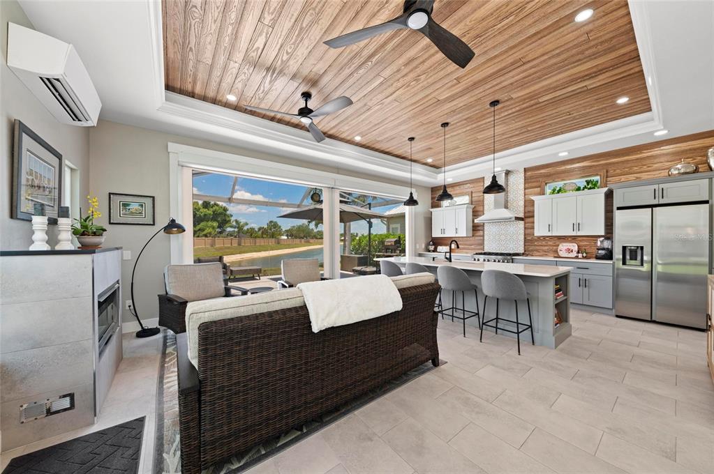 An open-concept kitchen and living area features a wood-paneled ceiling and large sliding glass doors — 8115 SW SAND CRANE CIRCLE LOT 2, ARCADIA, FL