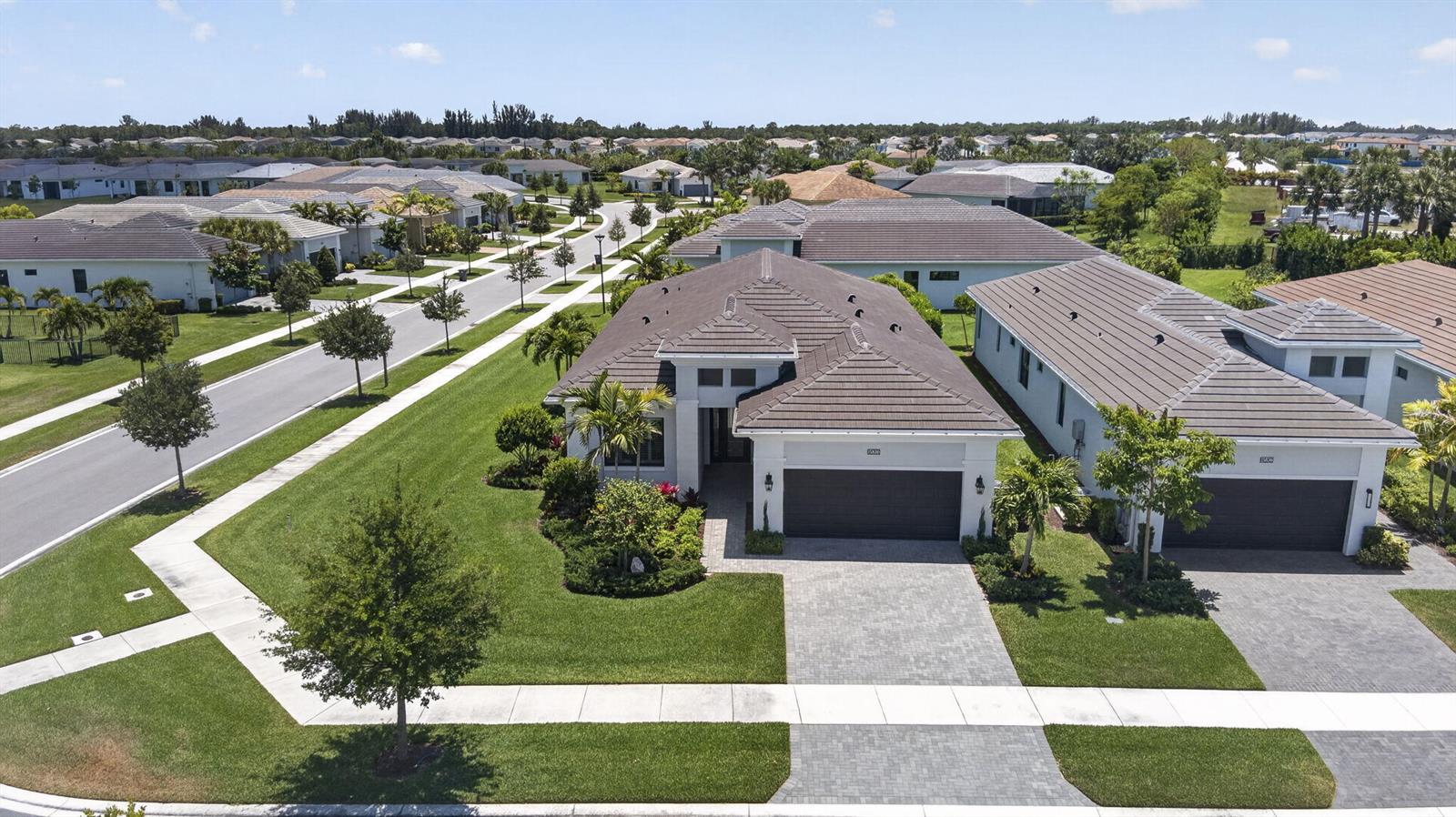 An aerial view shows a suburban house with a tiled roof and a paved driveway — 15830 Key Biscayne Lane, Westlake FL 33470, WESTLAKE, FL