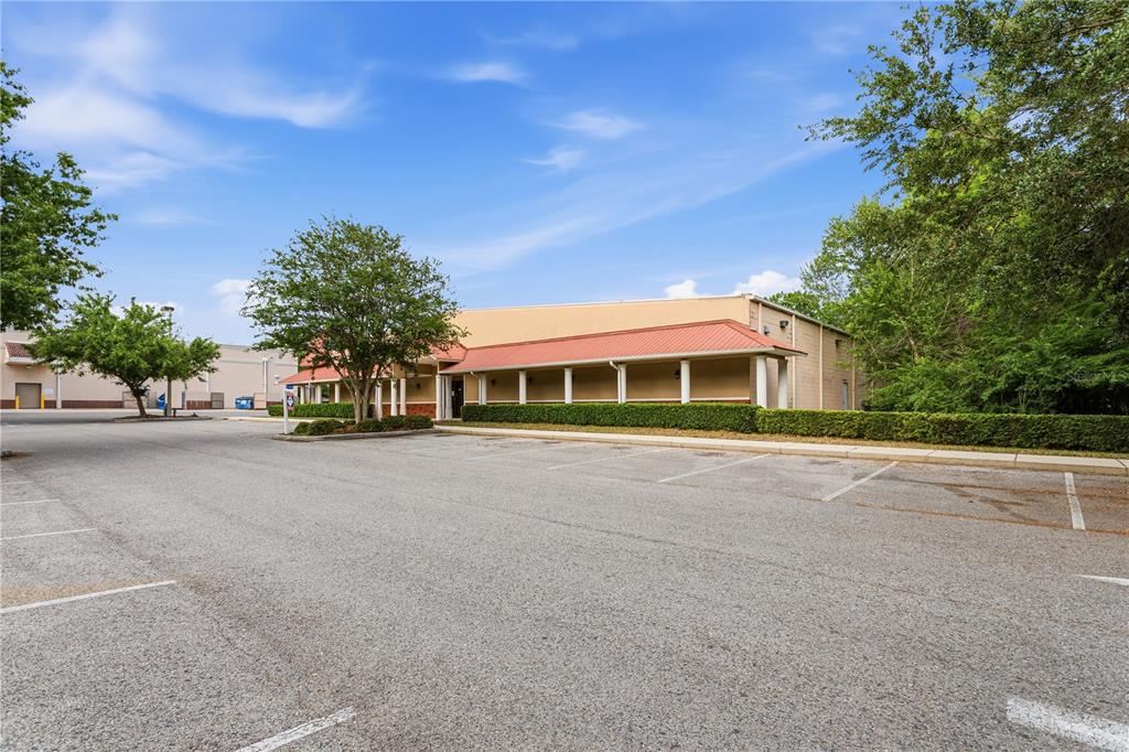 A single-story commercial building with a red metal roof and a paved parking lot — 15043 MAIN STREET, ALACHUA, FL