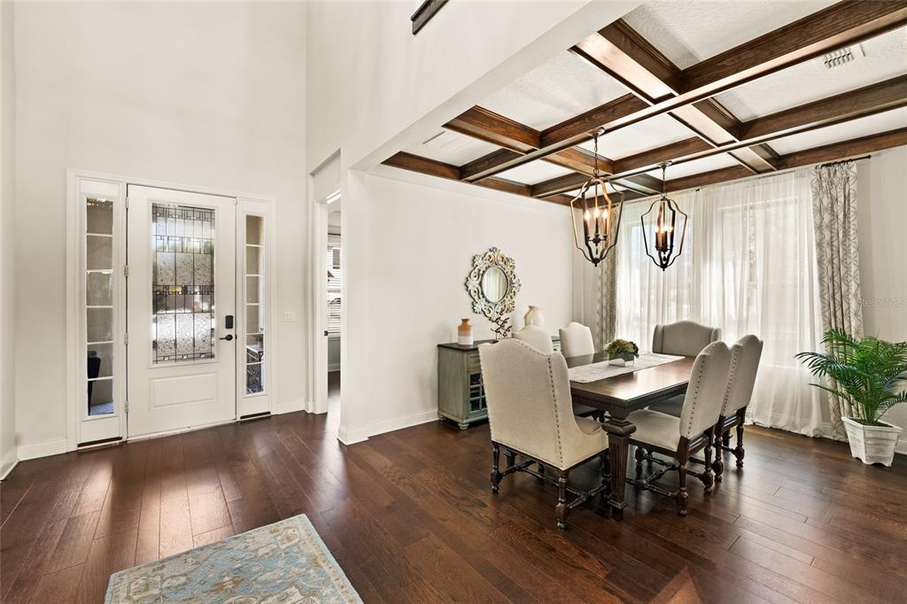 A dining room with a coffered ceiling, dark wood floors, and two hanging lantern lights — 13596 GORGONA ISLE DRIVE, WINDERMERE, FL