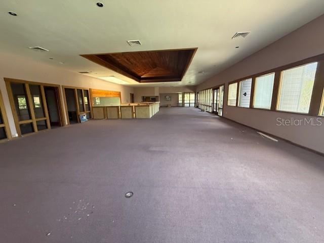 A large, carpeted room features a central wooden ceiling inset and a built-in bar area — 5736 S TEXAS AVENUE, ORLANDO, FL