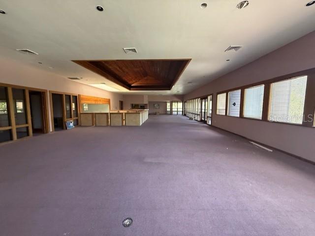 A large, empty room features purple carpeting, a recessed wood-paneled ceiling, and a long bar — 5736 S TEXAS AVENUE, ORLANDO, FL