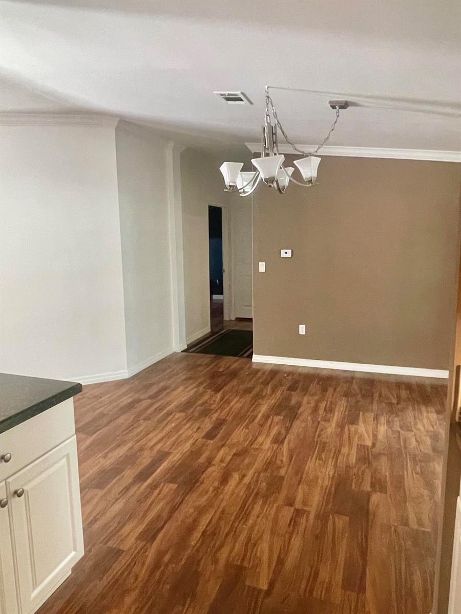 A dining area features wood-look flooring, a chandelier, and a brown accent wall — 195 Plantation Boulevard, Lake Worth FL 33467, LAKE WORTH, FL