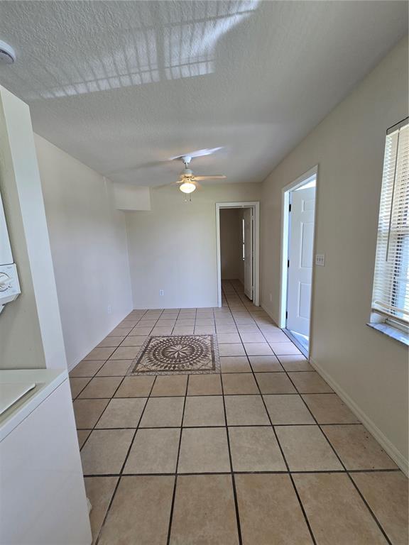 A room with beige tile flooring, a ceiling fan, and a decorative tile inlay — 2150 BARBARA DRIVE UNIT 2, ST CLOUD, FL