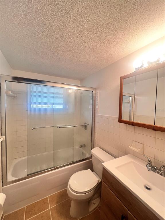 A bathroom features a shower-tub combination, a toilet, and a vanity with a medicine cabinet — 9910 LAKE CHRISE LANE, PORT RICHEY, FL
