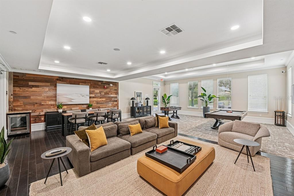 A spacious community lounge features a sectional sofa, pool table, dining area, and wood-paneled wall — 11128 GRANDE PINES CIRCLE UNIT Palm, ORLANDO, FL