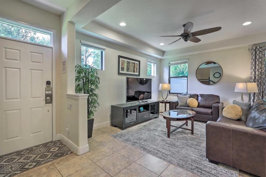 A living room features tile floors, a ceiling fan, a television console, and leather furniture — 8147 ROSEVILLE BOULEVARD, DAVENPORT, FL