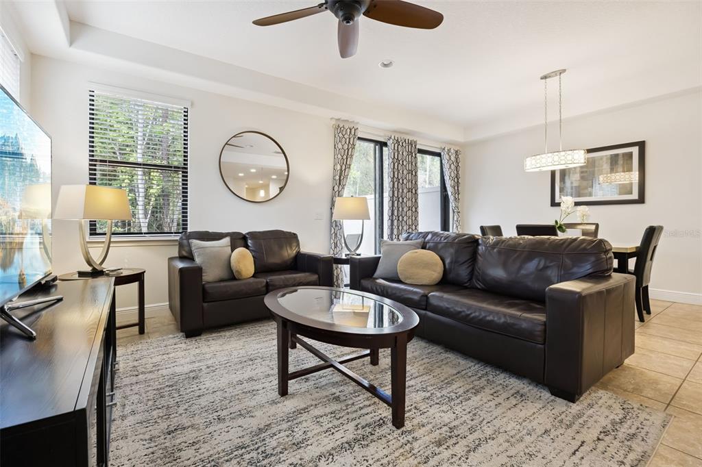 A living room features dark leather sofas, a glass-topped coffee table, and a dining area — 8147 ROSEVILLE BOULEVARD, DAVENPORT, FL