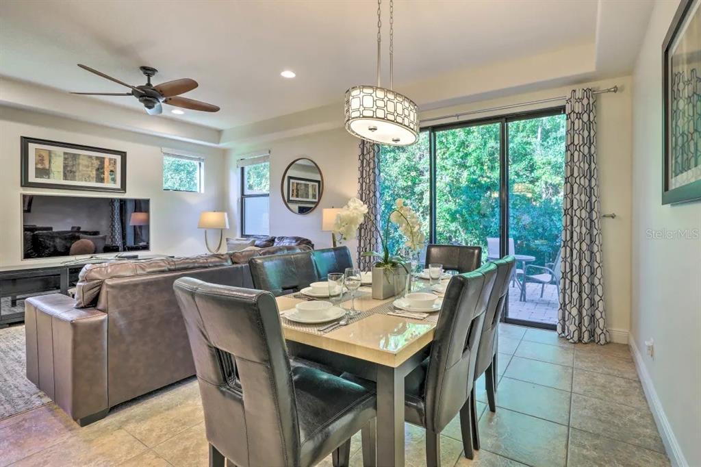 A dining area with a table and chairs sits adjacent to a living room — 8147 ROSEVILLE BOULEVARD, DAVENPORT, FL