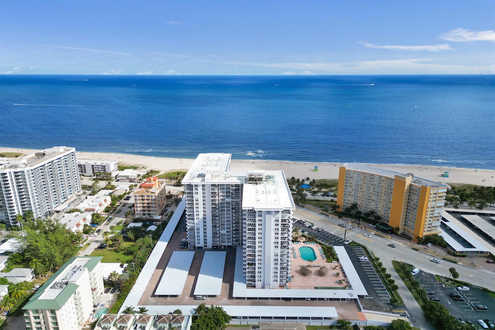 An aerial view shows a white high-rise apartment building near a beach and ocean — 405 N Ocean Boulevard # 305, Pompano Beach FL 33062, POMPANO BEACH, FL