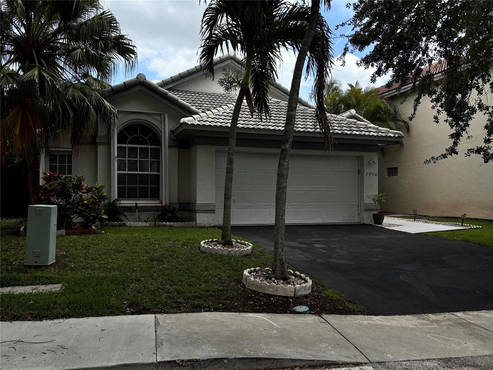 A single-story house with a white stucco exterior, tile roof, and two palm trees — 2990 NW 68th Avenue, Margate FL 33063, MARGATE, FL