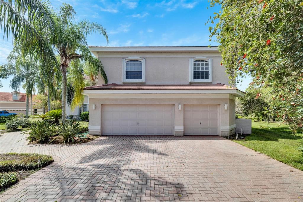 A two-story house with a beige stucco exterior and a three-car garage — 17904 CACHET ISLE DRIVE, TAMPA, FL