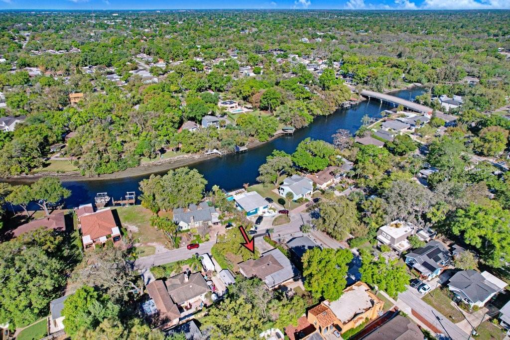 An aerial view shows a residential neighborhood with a river and a bridge — 6703 N RIVER BOULEVARD, TAMPA, FL