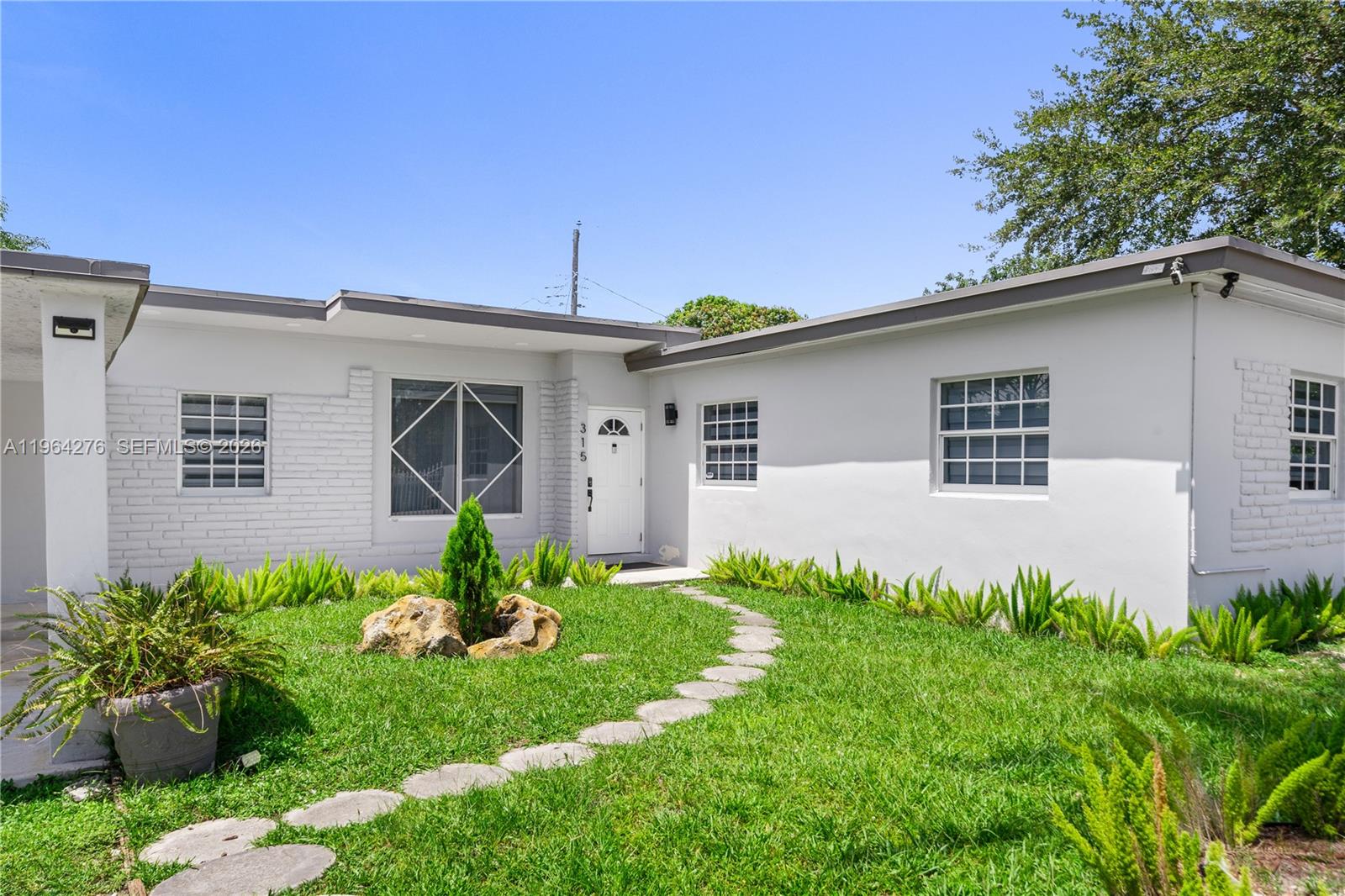 A single-story white house features a stone path leading to the front entrance — 315 NW 106th ST, Miami FL 33150, MIAMI, FL