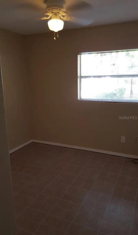 An empty room with tan walls, a ceiling fan, and tiled flooring — 1235 MORGAN DRIVE, LAKELAND, FL