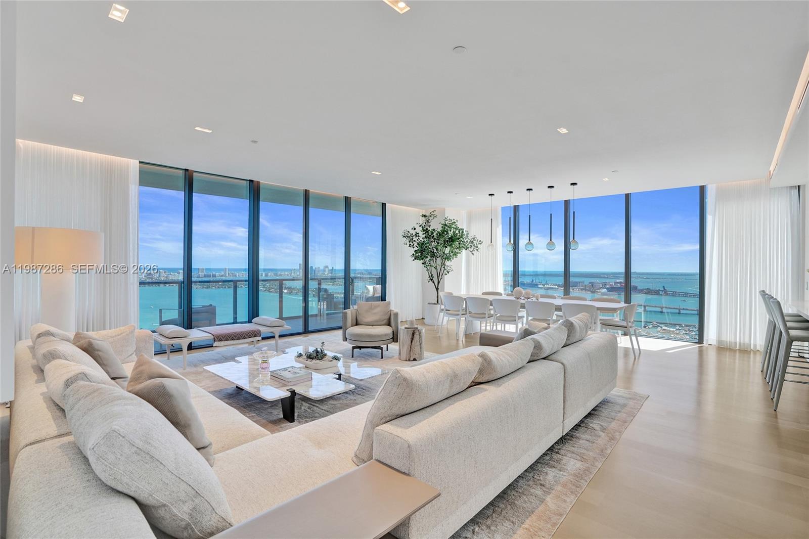 A spacious living and dining area features floor-to-ceiling windows with expansive ocean and city views — 788 NE 23rd St # 3801, Miami FL 33137, MIAMI, FL