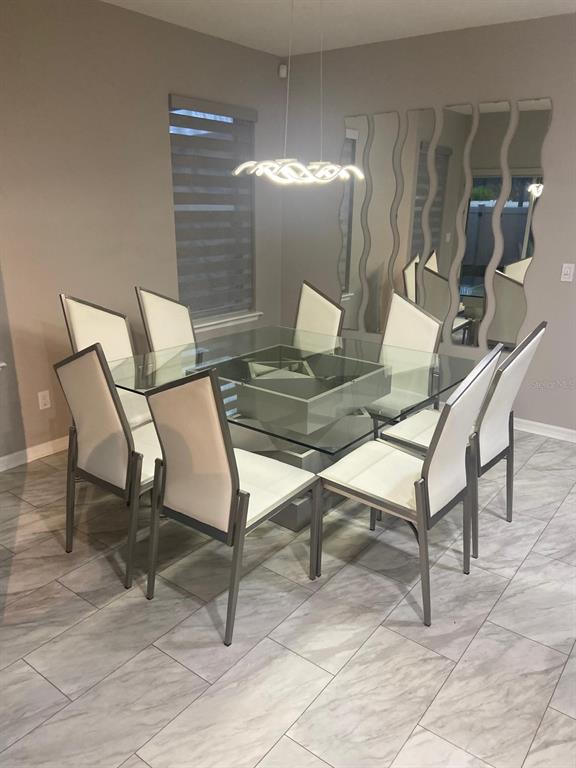 A dining room features a glass-topped table, eight chairs, and wavy wall mirrors — 2618 SAN SIMEON WAY, KISSIMMEE, FL