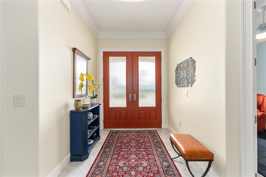 An entryway features a red double door, a blue console table, and a patterned rug — 8671 SW 83RD LOOP, OCALA, FL