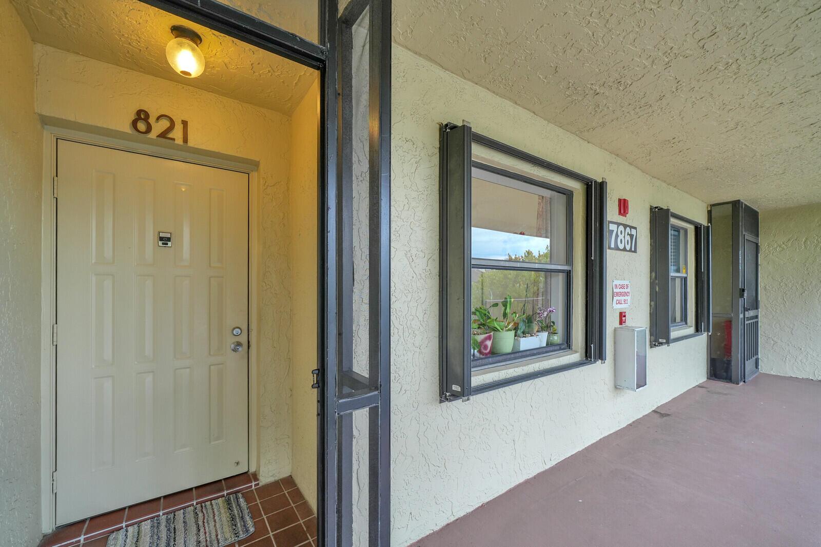 An exterior view of a building entrance with a door numbered 821 and a window — 7867 Willow Spring Drive # 821, Lake Worth FL 33467, LAKE WORTH, FL